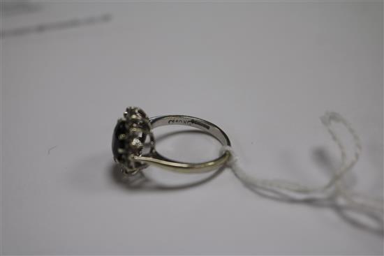 A 9ct white gold, sapphire and diamond oval cluster ring, size L.